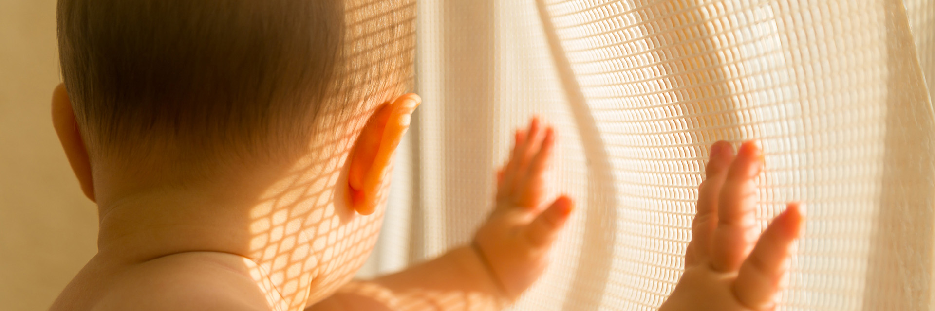 Baby looking out window yellow light